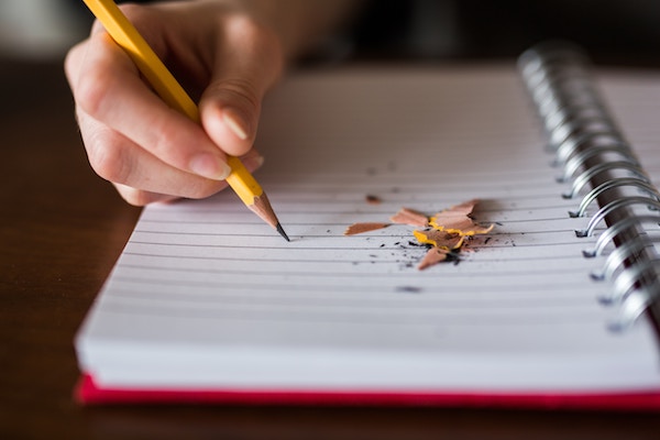 photo of sharpened pencil on notebook page with pencil shavngs