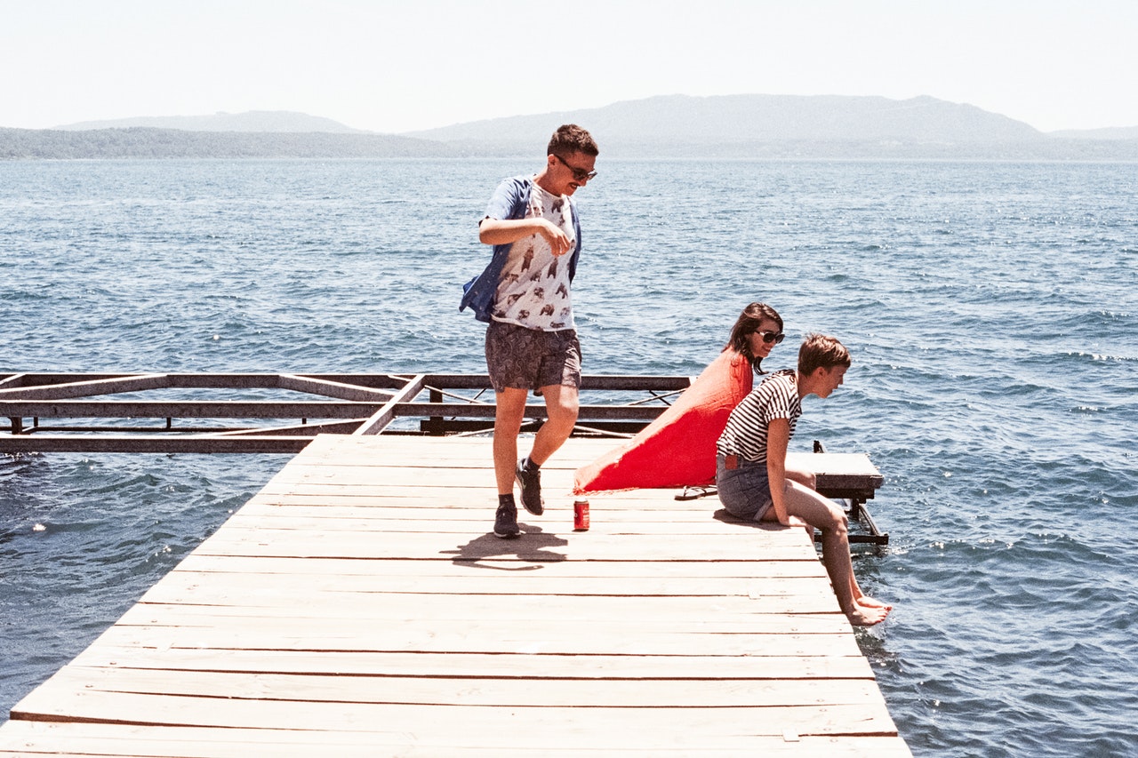 teens on pier over lake