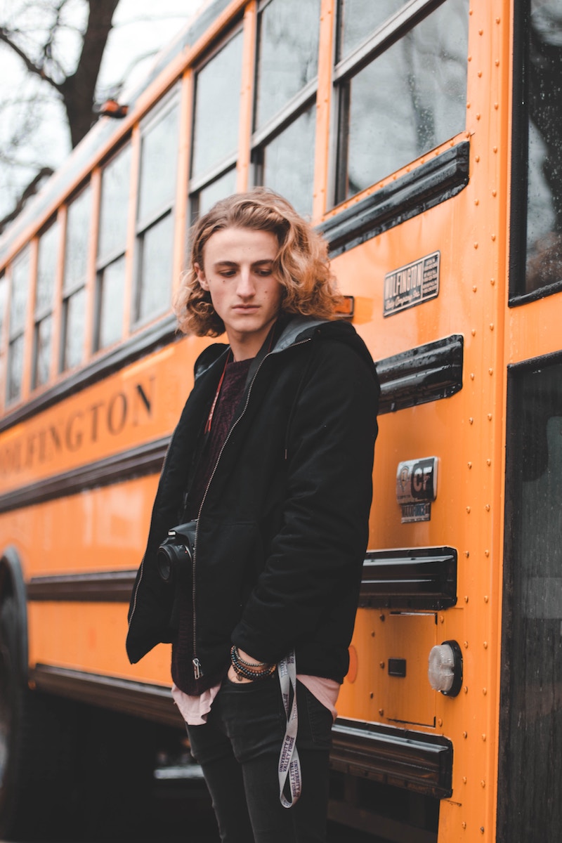 teen boy at school bus door