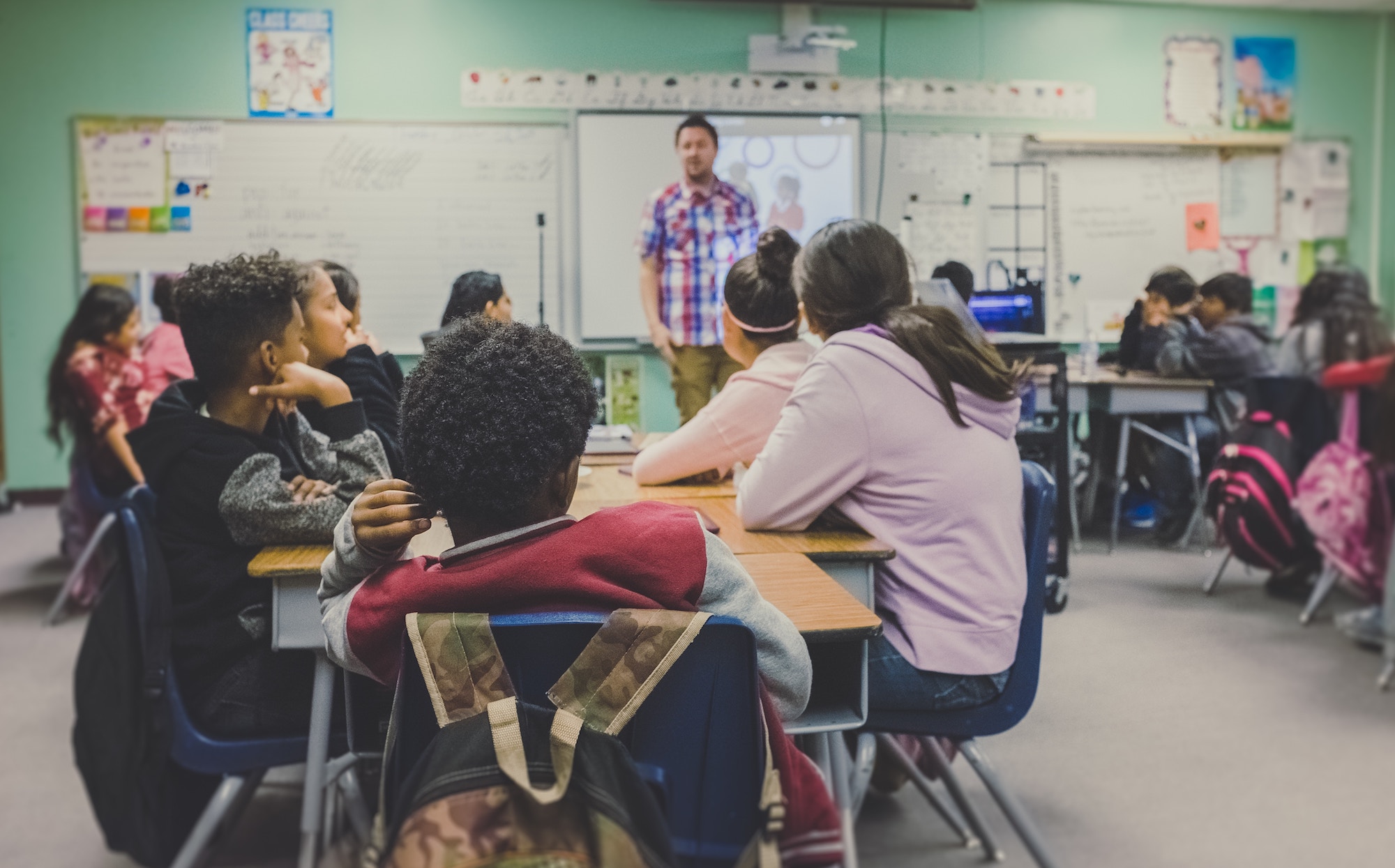 classroom with students lookin gat teacher in front of white board