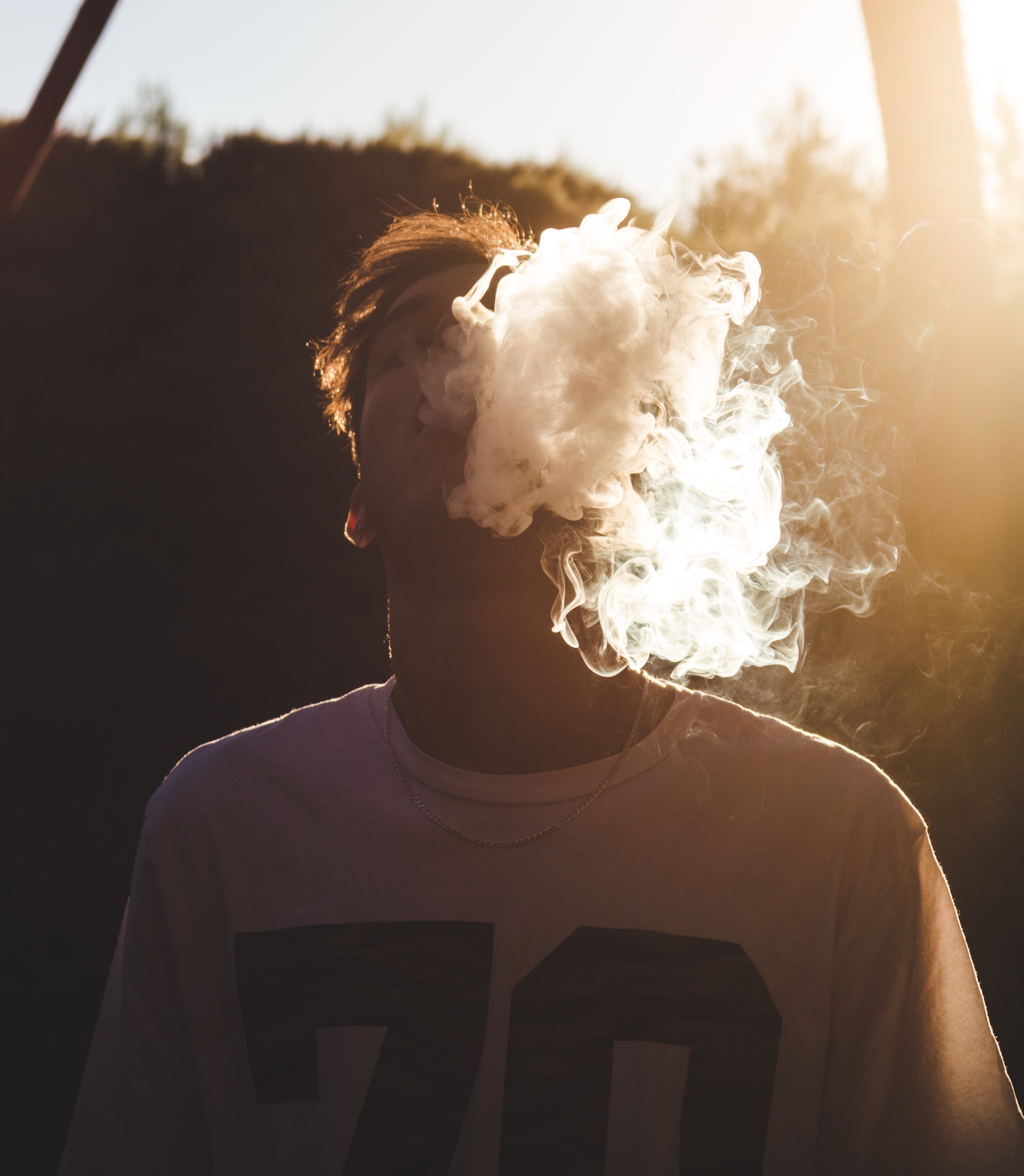 young man vaping in football jersey